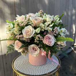 Bouquet of pale pink roses and white flowers in a pink textured box