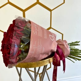 Bouquet of red roses wrapped in pink paper with a ribbon