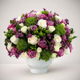 Bouquet of pink, white, and purple roses in a white vase