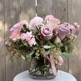 Pink rose bouquet in a clear glass vase with ribbon