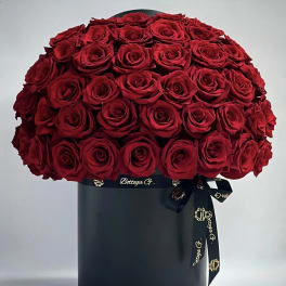Large bouquet of red roses in a black hat box with ribbon