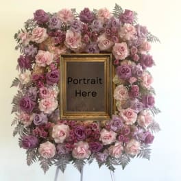 Floral frame of pink and lavender roses around a portrait opening
