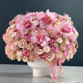 Pink rose bouquet in a white vase with ribbon