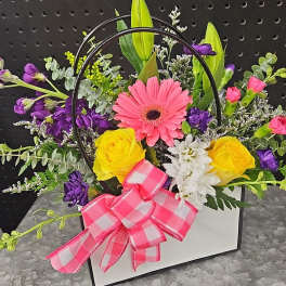 Mixed flower arrangement in a white box with a pink bow