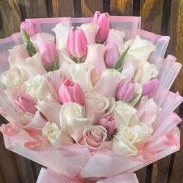Pink and white tulip bouquet wrapped in pink paper with a bow