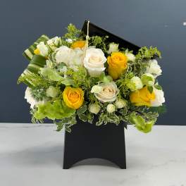 Bouquet of white and yellow roses in a black box