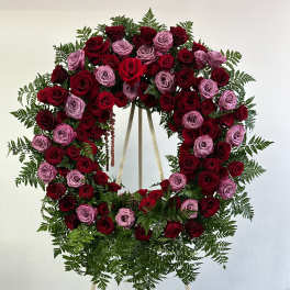 Heart-shaped wreath of red and lavender roses on an easel