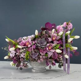 Purple floral arrangement with white tulips in a silver vase