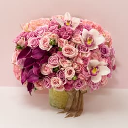 Pink rose bouquet with white orchids in a gold vase