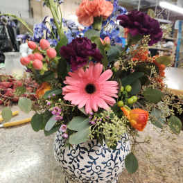 Mixed bouquet in a patterned ceramic vase with pink and purple flowers