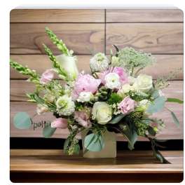 Pink and white floral arrangement in a square vase
