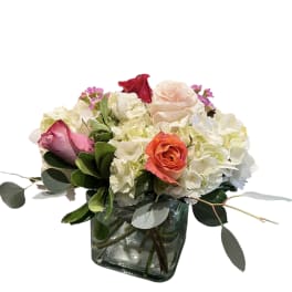 Mixed bouquet of roses and white hydrangeas in a glass vase