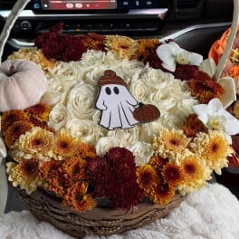 Basket of white roses and autumn mums with a small ghost decoration