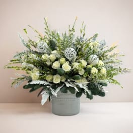 White rose arrangement in a gray vase with silver accents