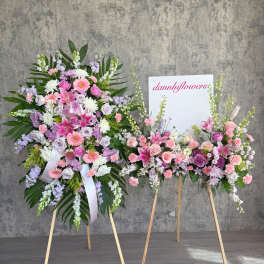 Two pastel floral standing sprays on easels with pink and lavender blooms