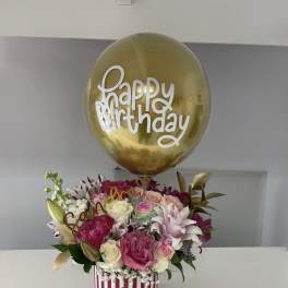Birthday bouquet with pink and white roses under a gold balloon