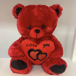 Red teddy bear holding a heart that says "Love you"
