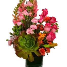 Mixed bouquet with pink roses, carnations, and succulents in a glass vase
