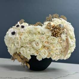 Cream rose bouquet in a black vase with gold ornaments