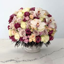Large bouquet of roses and white orchids in a low pedestal vase