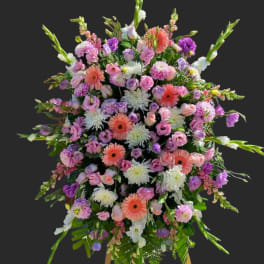 Large standing spray of pink, purple, and white flowers on an easel