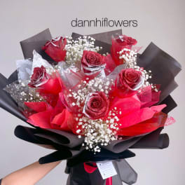 Bouquet of red roses with baby's breath wrapped in black paper
