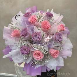 Bouquet of pink and purple roses wrapped in lavender paper