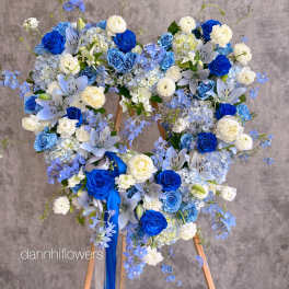 Blue and white floral wreath on a wooden stand