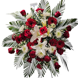 Standing floral spray with red roses, white lilies, and gerbera daisies
