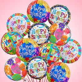 Cluster of colorful birthday balloons against a pink background