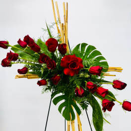 Red roses arranged with tropical leaves on a stand