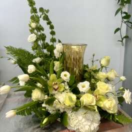 White and pale yellow floral arrangement with a gold vase centerpiece