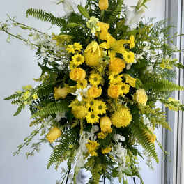Tall yellow and white floral standing spray on a black easel