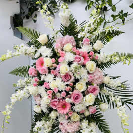 Large standing floral spray with pink and white flowers on an easel