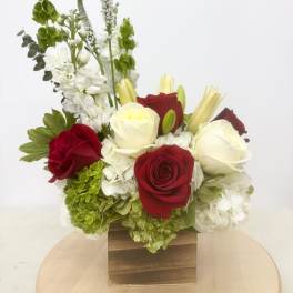 Red and white roses with white hydrangeas in a wooden box
