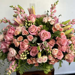 Large pink rose arrangement with lilies and snapdragons in a vase