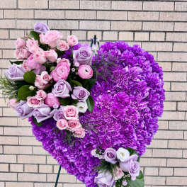 Heart-shaped purple floral standing arrangement with pink and lavender roses