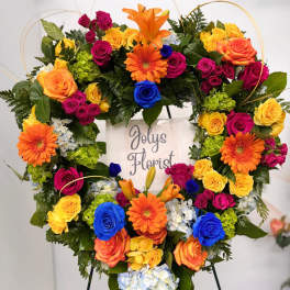 Heart-shaped floral wreath with multicolored roses and gerbera daisies