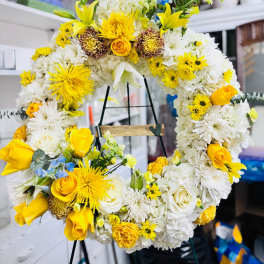 Yellow and white floral wreath on a stand