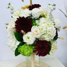 Bouquet of white and burgundy flowers in a glass vase