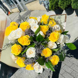 Bouquet of yellow and white roses with purple filler flowers