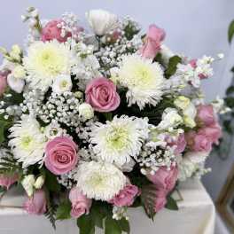 Pink roses and white chrysanthemums arranged in a low bouquet