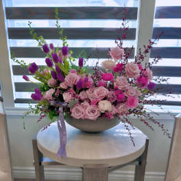 Pink roses and purple tulips arranged in a low bowl