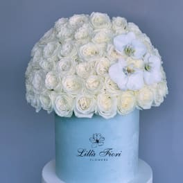 White rose arrangement in a light blue hat box with white orchids