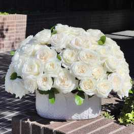 White rose arrangement in a textured white vase