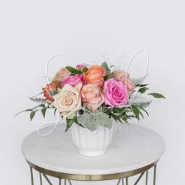 Mixed roses in a white vase on a round table