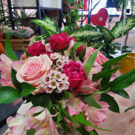 Pink and red roses with pink alstroemeria in a clear glass vase.