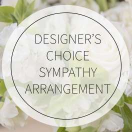 White sympathy arrangement with pale green flowers and a circular text overlay