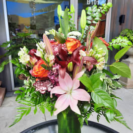 Mixed bouquet in a green vase with lilies and roses