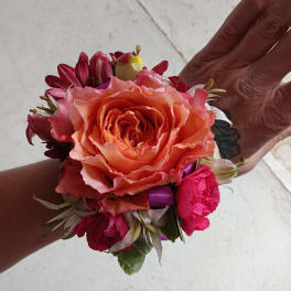Handheld corsage with a peach rose and pink flowers